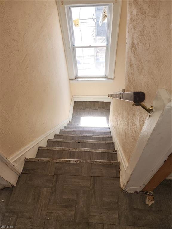Stairs featuring dark parquet floors