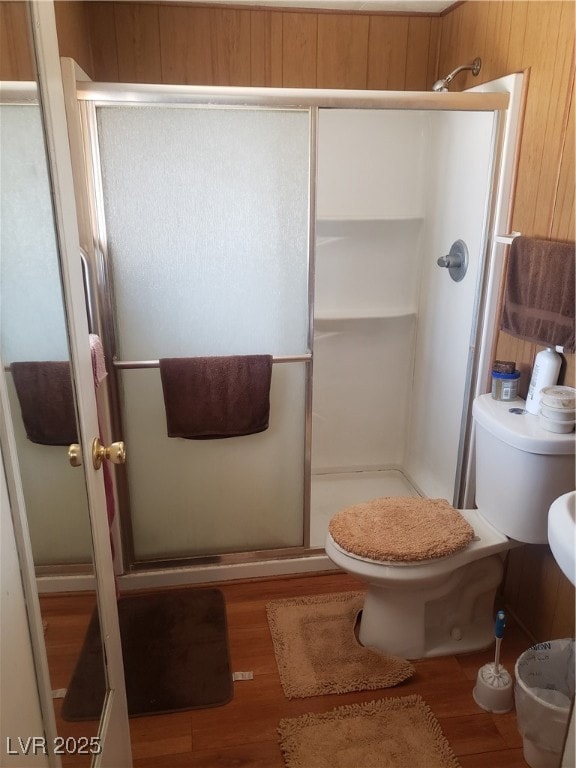 Bathroom featuring a stall shower, wood finished f