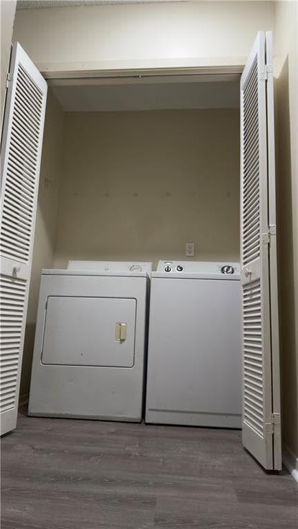 Laundry area featuring wood finished floors and washer and clothes dryer