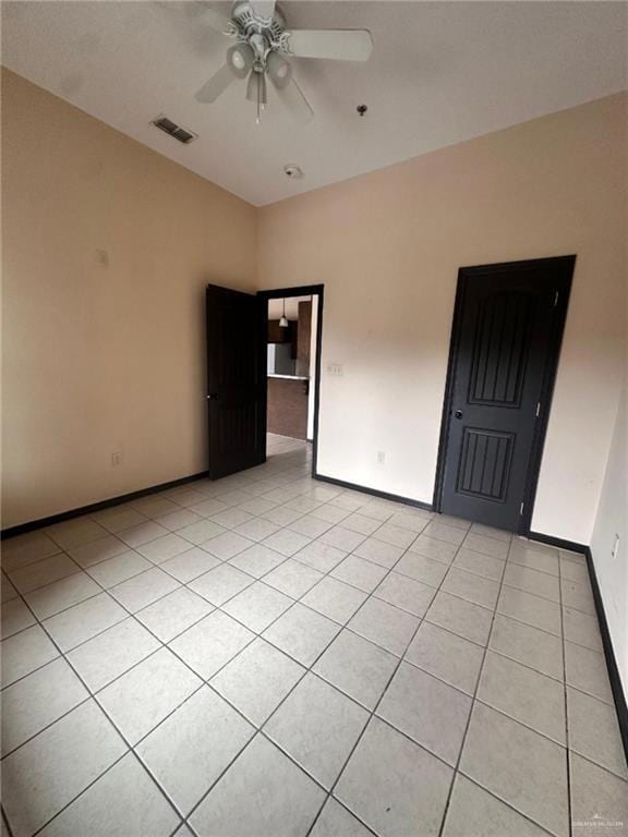 Spare room with ceiling fan and light tile patterned floors