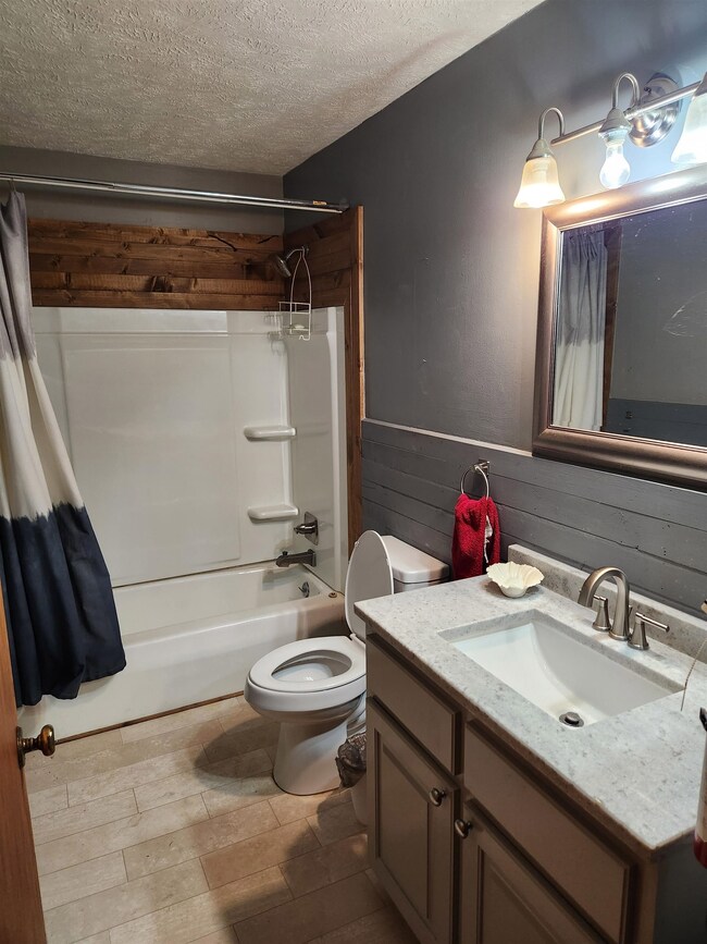 Full bathroom with toilet, vanity, hardwood / wood