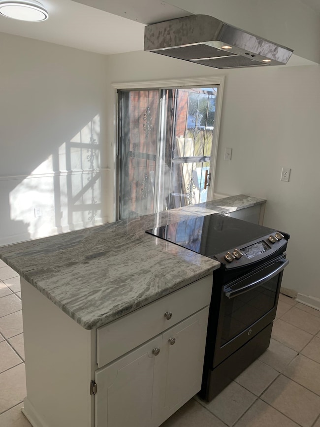 Kitchen with light tile patterned flooring, white 