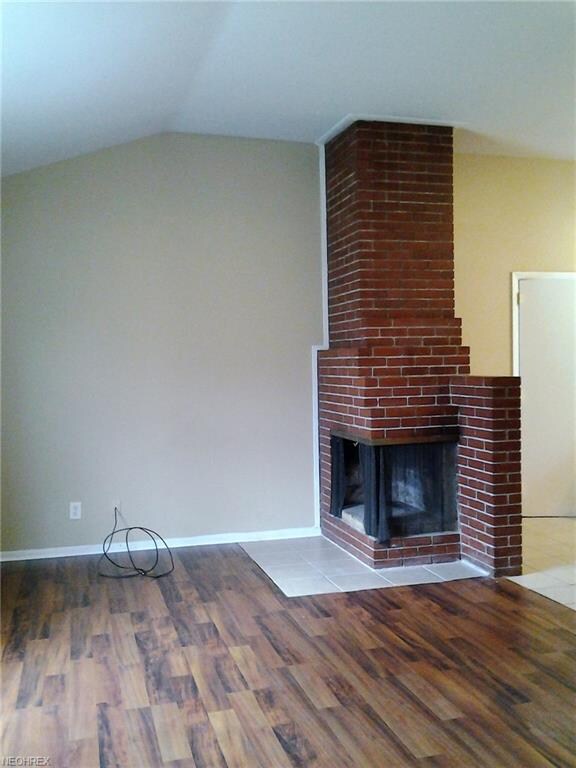 Vaulted Living room featuring dual sided, brick wo