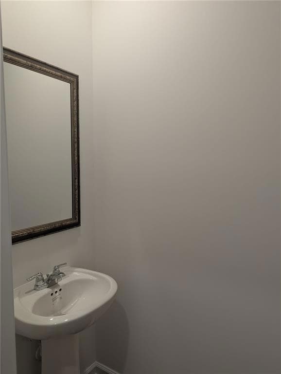 Bathroom featuring a sink and baseboards