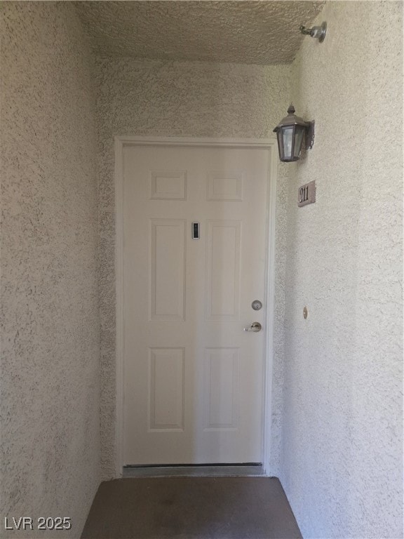 Doorway to property featuring stucco siding
