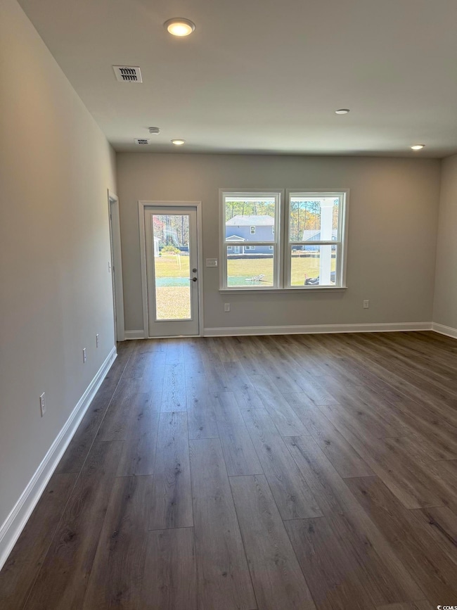 Unfurnished living room featuring baseboards, visi