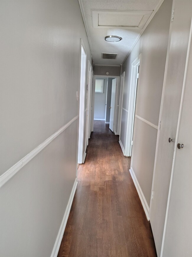 Hall featuring ornamental molding and dark wood-ty
