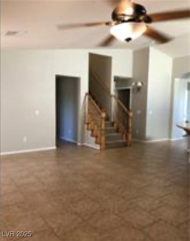 Unfurnished living room featuring a ceiling fan an