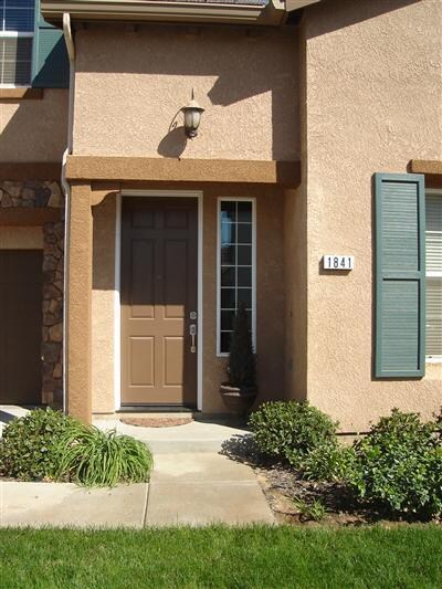 Sheltered front porch with tall front entry door.
