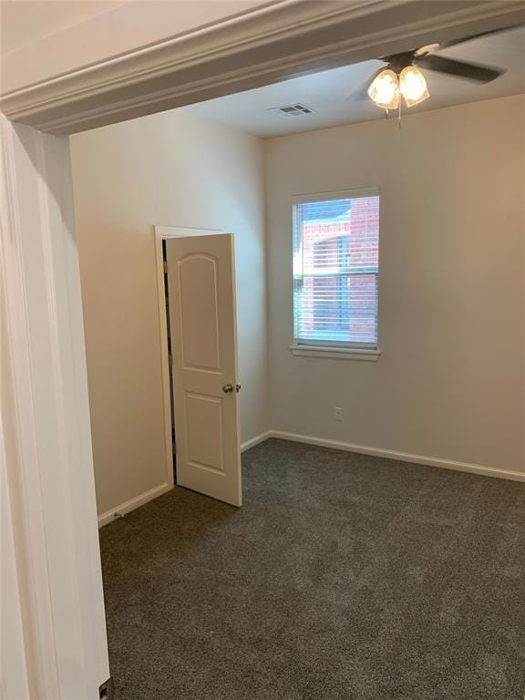 Empty room with dark colored carpet, ceiling fan, 