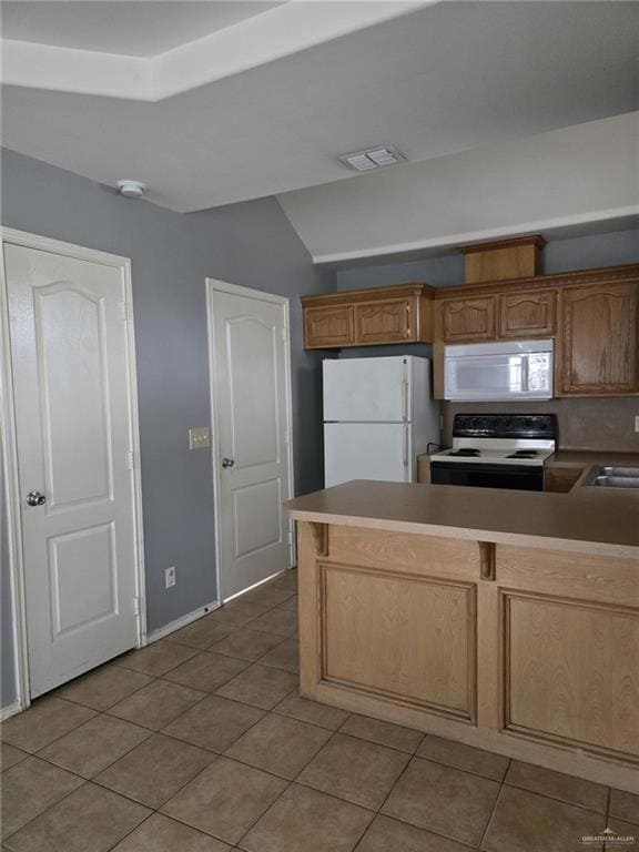 Kitchen featuring kitchen peninsula, light tile patterned floors, white appliances, and sink