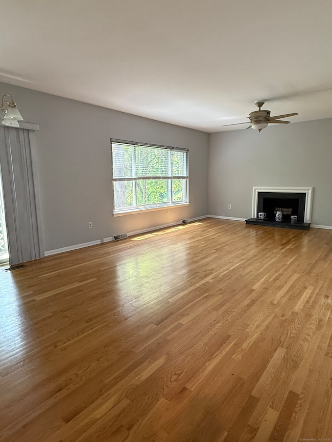 Spacous and bright Living/Dining area with large windows, deck, working fireplace and hardwood floors