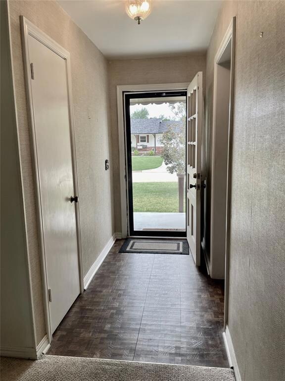 Doorway to outside with dark hardwood / wood-style