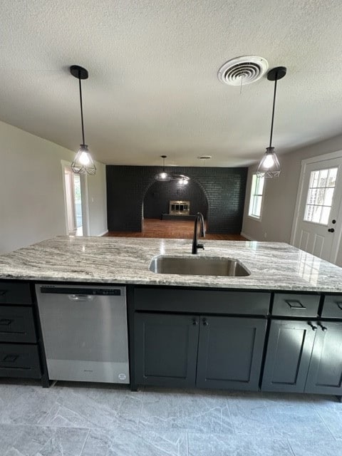 Kitchen featuring decorative light fixtures, light stone counters, dishwasher, a textured ceiling, and open floor plan