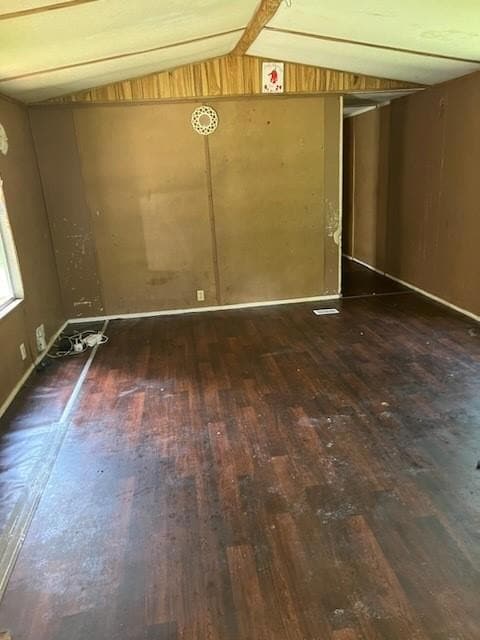 Unfurnished room with wood-type flooring and vault