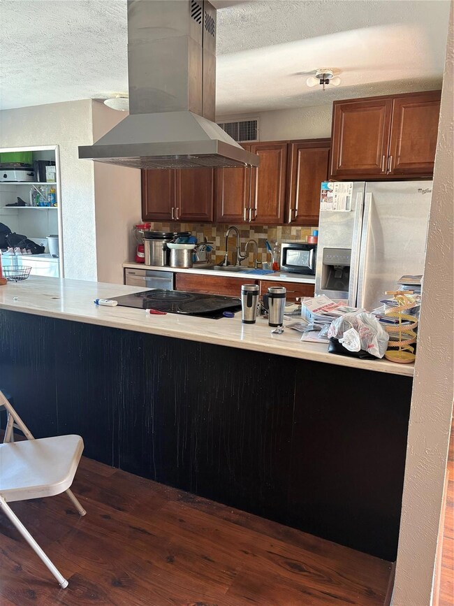 Kitchen featuring refrigerator, range hood, kitche