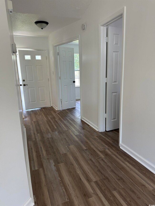 Entryway with dark wood-style flooring, baseboards