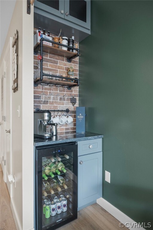 Bar featuring beverage cooler, light wood-type flo
