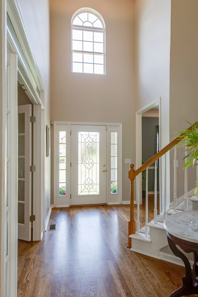 Notice the palladium window. Couple with the glass front door this home gets bathed in natural light throughout the day. Just through the glass french doors is the office.