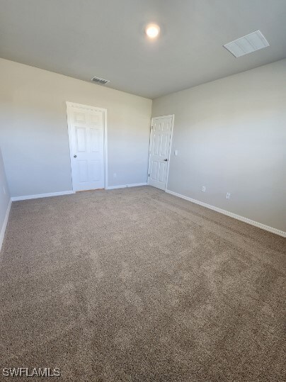 Carpeted spare room with baseboards and visible ve