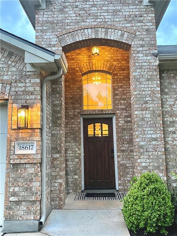 Doorway to property featuring brick siding and st