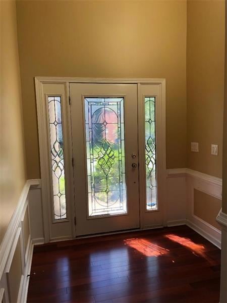 Foyer entrance featuring a wainscoted wall, dark w