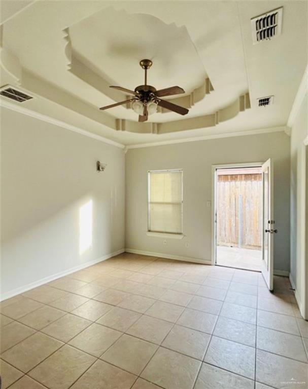 Primary Bedroom with a raised ceiling, light tile patterned flooring, crown molding, and a ceiling fan