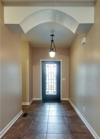 Dramatic arches in this elegant foyer. New tile flooring and new custom door. Beautiful crown molding throughout the home.