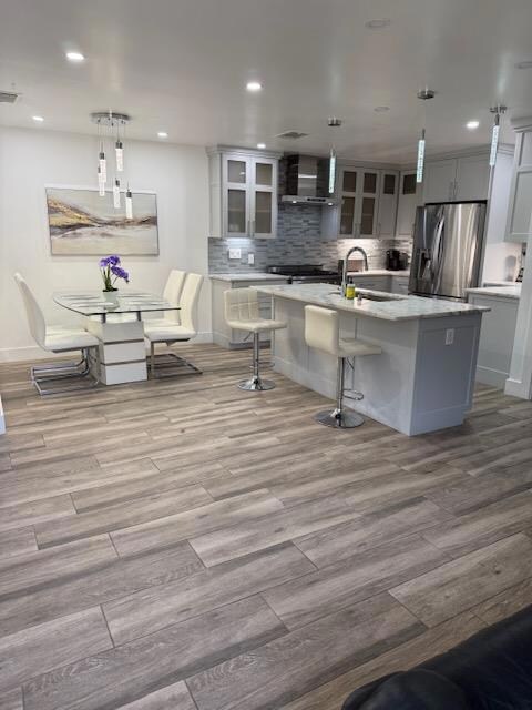 Kitchen with stainless steel fridge, wood finishe