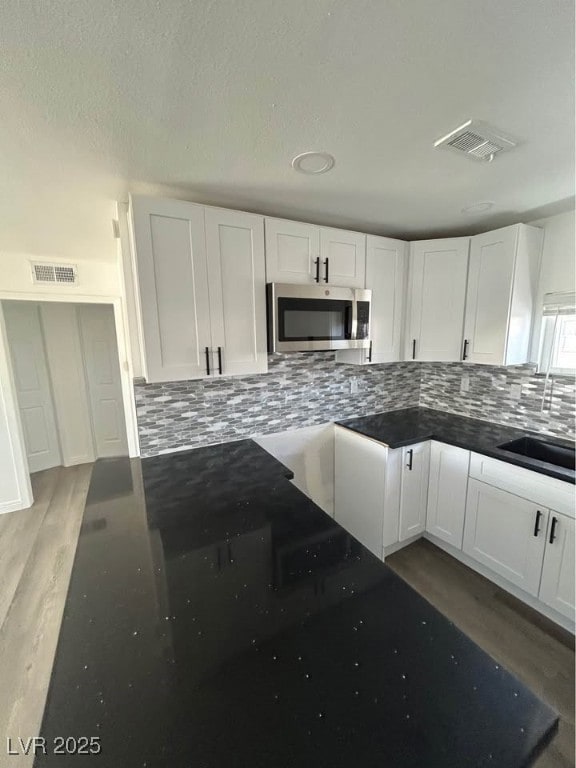 Kitchen featuring stainless steel microwave, white