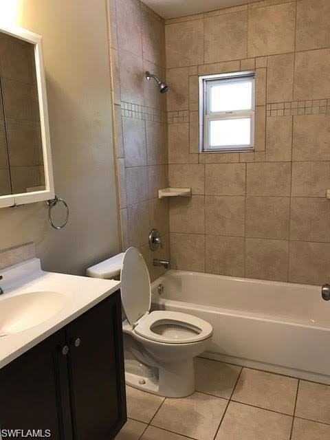 Bathroom with tile patterned flooring, bathtub / shower combination, vanity, and toilet
