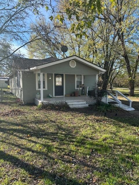 Single story home featuring a porch and a front ya