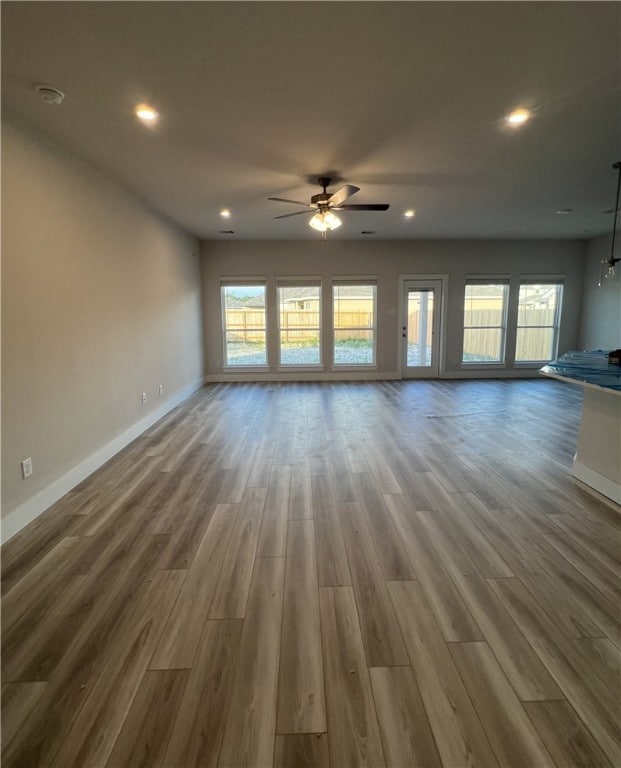 Unfurnished living room featuring wood finished fl