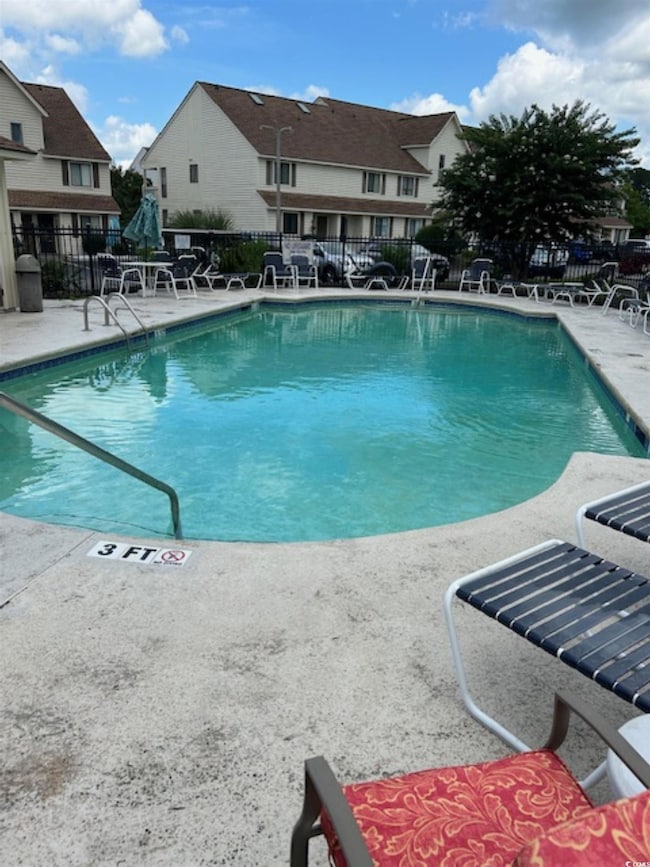 Community pool featuring a patio and a residential view