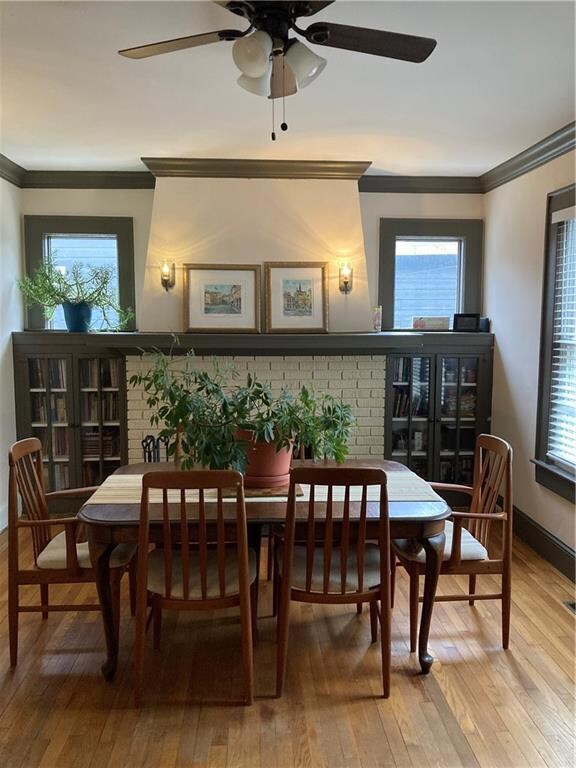 Dining space featuring crown molding, wood-type flooring, and a ceiling fan