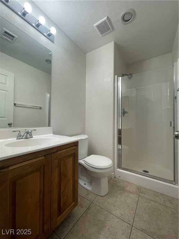 Bathroom featuring vanity, a stall shower, light tile patterned floors, and a textured ceiling