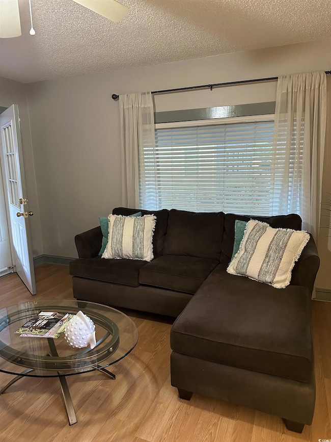 Living area with a textured ceiling and wood finished floors
