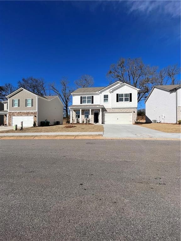 Traditional-style home with concrete driveway, bri