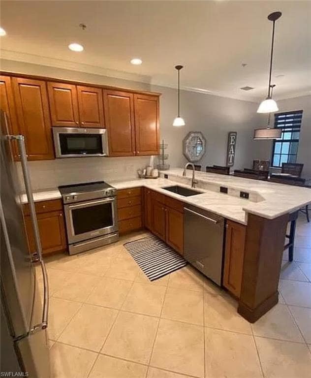 Kitchen featuring decorative light fixtures, brown
