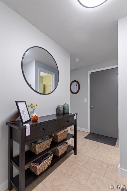 Foyer with tile flooring and door that leads to th