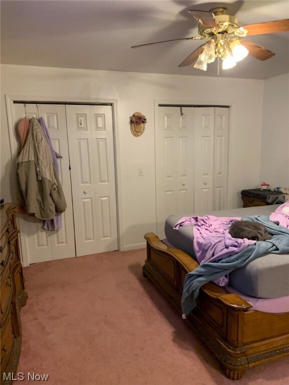 Carpeted bedroom featuring ceiling fan
