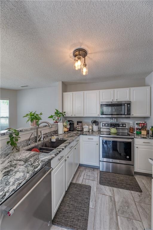 KITCHEN:  Updated Kitchen features updated Cabinets and Granite Countertops, Sink and Fixtures, Tile Flooring and SS Appliances.