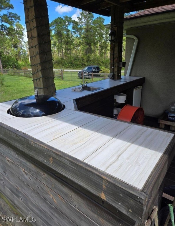 Wooden deck featuring a lawn and sink