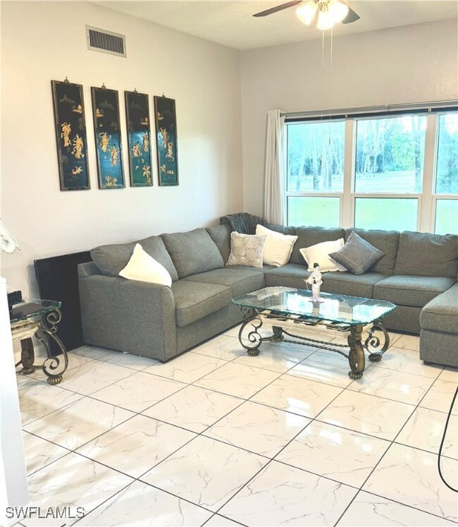 Living area featuring marble look tiles and a ceil