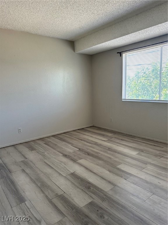 Spare room featuring wood finished floors and a te