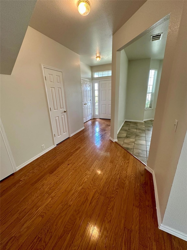 Empty room featuring wood finished floors and a t