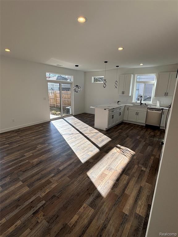 Kitchen featuring recessed lighting, white cabinets, a peninsula, healthy amount of natural light, and dishwasher