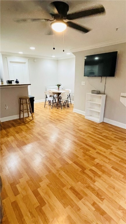 Living area with ceiling fan, baseboards, wood fin