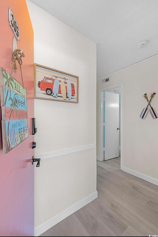 Foyer featuring light wood-style floors and a textured ceiling