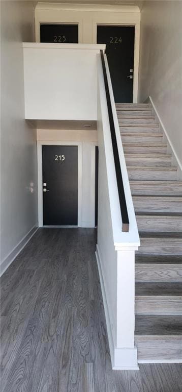 Staircase with baseboards and wood finished floors
